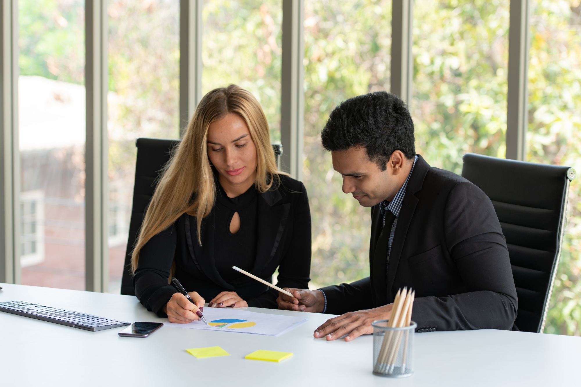 Both of young business analyze data and consult various issues