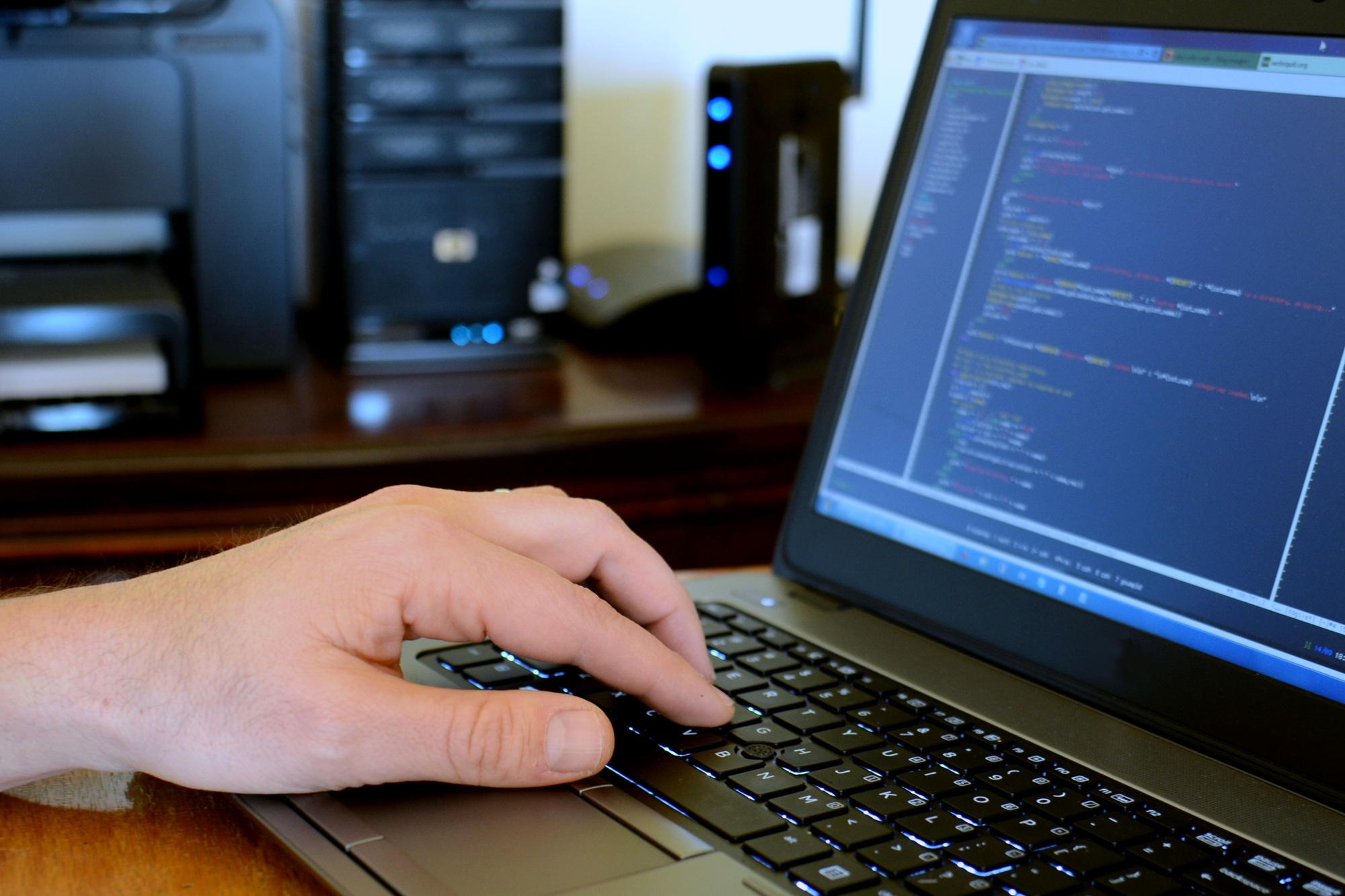 Male programmer working on computer code on his laptop. Data screen - data entry office IT Dept